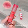 Lip oil with strawberry design held by a hand, close-up of lips with product application.