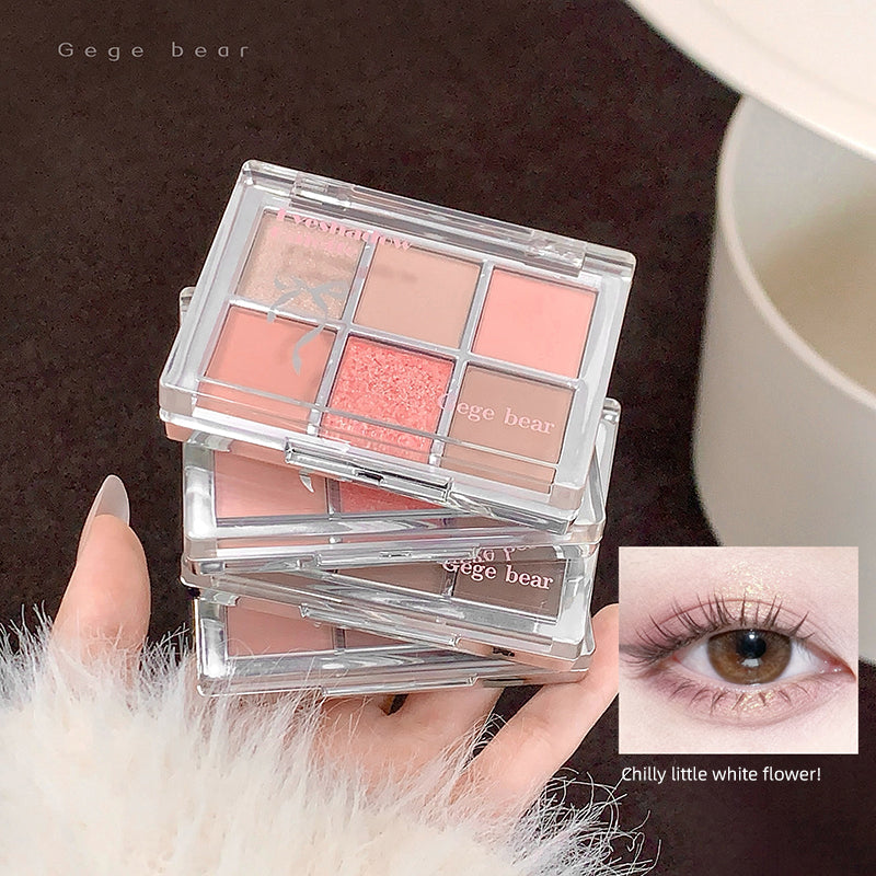 Makeup palette with blush shades held by a hand, with an inset of an eye wearing the makeup.