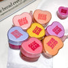 Heart-shaped GEGE BEAR lip balms in various colors on a white surface.