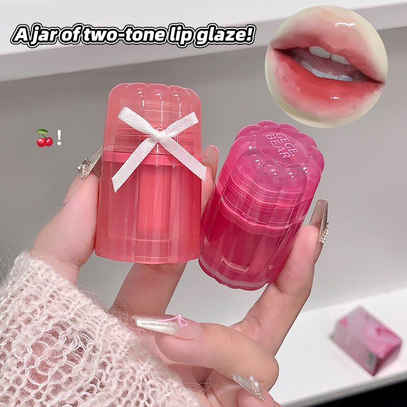 Two-tone lip glaze in pink and clear packaging held by a hand, with a close-up of lips wearing the product.