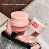 Pink makeup product held by a hand with a blurred background