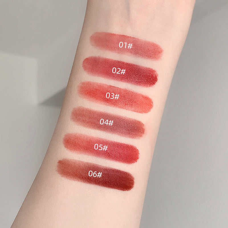 Lipstick swatches on a person's arm with color labels.
