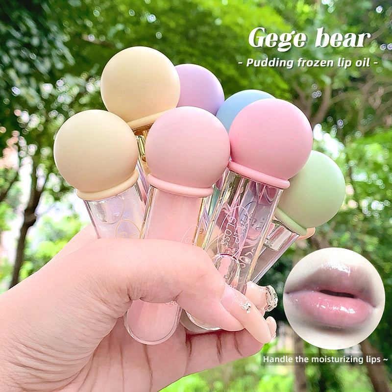 Pastel-colored lip oil bottles held in a hand with a blurred green outdoor background