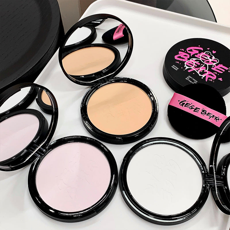Makeup compacts with visible brand names on a white surface