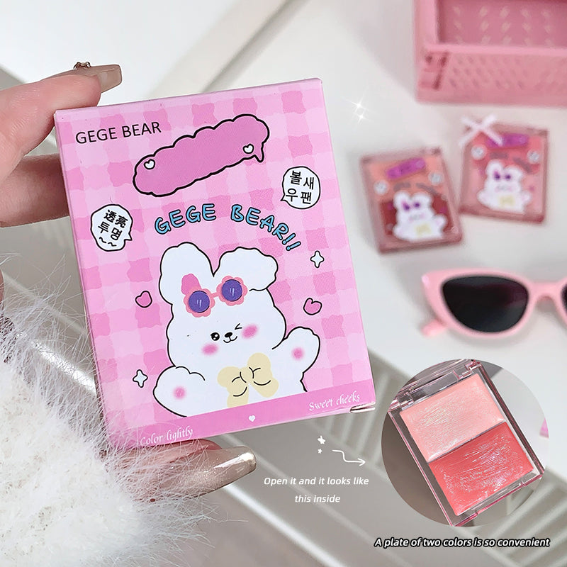 Pink GEGE BEAR product packaging held by a hand, with sunglasses and another product in the background.