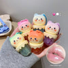 Set of cute, colorful character figurines held in a hand with a gray sleeve.