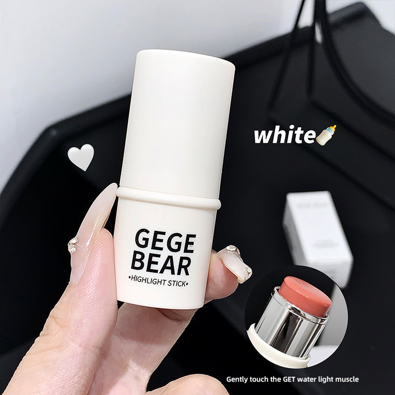 Hand holding a white highlight stick with 'GEGE BEAR' branding against a blurred background.