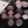 Makeup products with 'Coco Peru' branding on a dark surface.