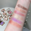 Color swatches of glittery makeup on a person's arm with compact mirrors in the background.