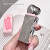 Silver lip gloss with pink packaging held by a hand on a white background