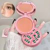 Pink makeup compact with 'GEGE BEAR' branding held by a hand, with a close-up of skin before application.