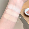 Three swatches of a cosmetic product on a person's arm with labels indicating different shades.