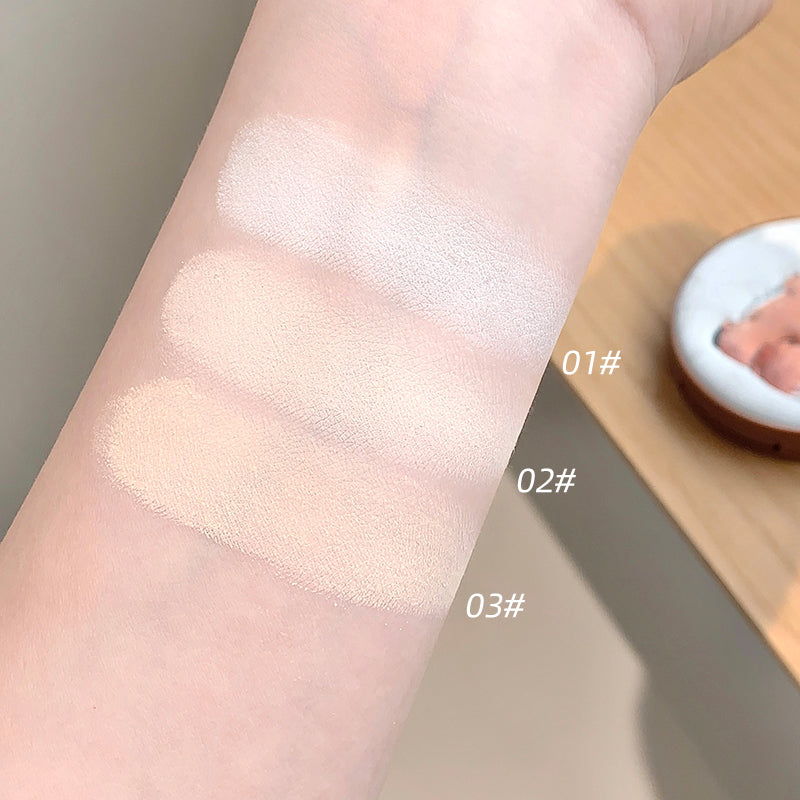 Three swatches of a cosmetic product on a person's arm with labels indicating different shades.