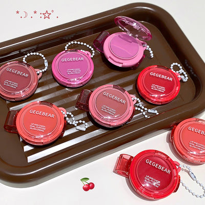 Set of GEGBEAR lip products on a brown tray with cherry graphics.