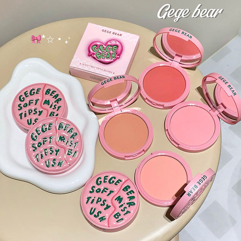 Gege Bear blush products on a beige surface with packaging in the background.