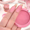 Pink blush compact with a hand holding it, showing the color on nails.