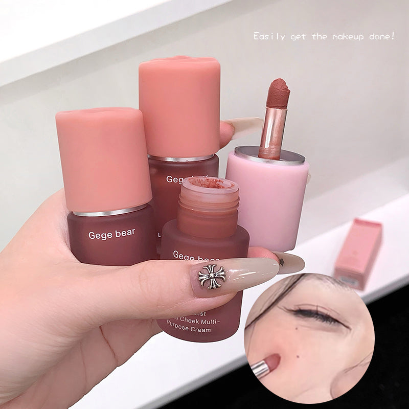 Hand holding makeup products with 'Gege bear' branding, including lipsticks and a cream.
