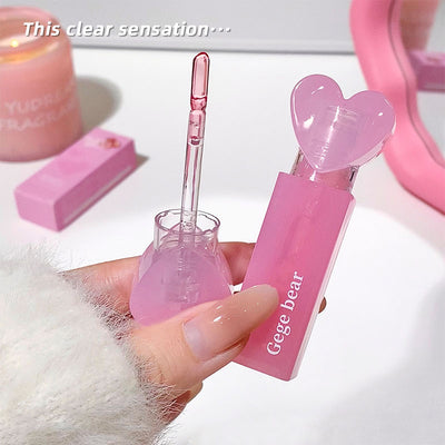 Pink cosmetic product with heart-shaped design held by a hand, with 'Gege bear' branding.