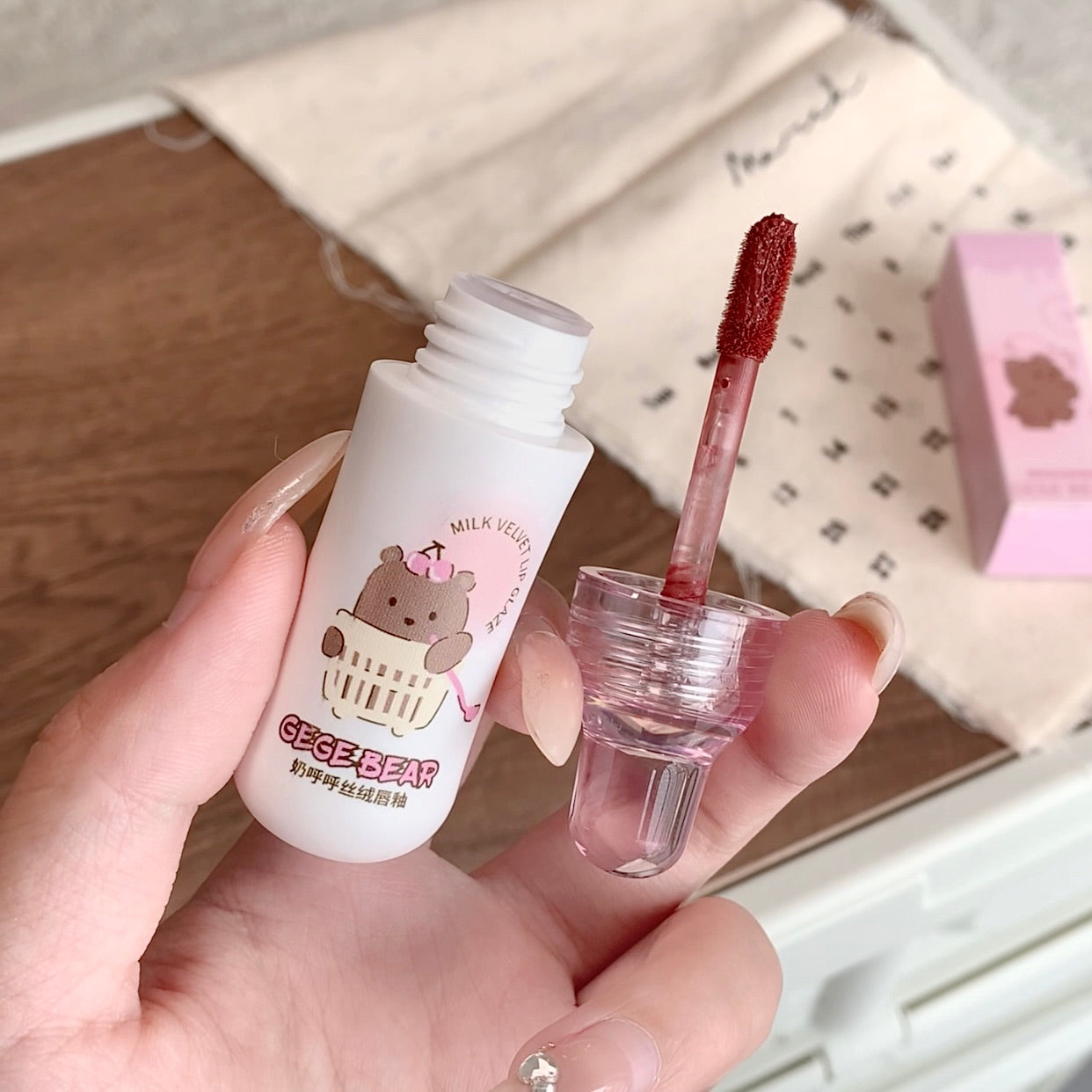 Lip tint with a bear character label held in a hand