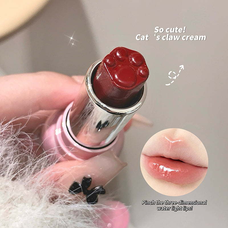 Pink lipstick with a paw design on the cap, held by a hand, with a close-up of lips wearing the lipstick.