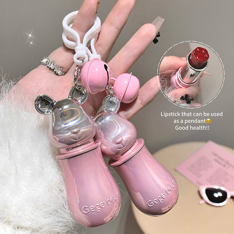 Pink lipstick pendant with a hand holding it, on a neutral background.
