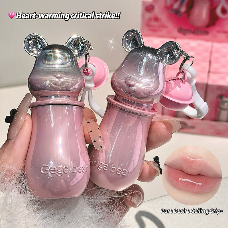 Two pink bear-shaped lip balms held by a hand with a blurred background