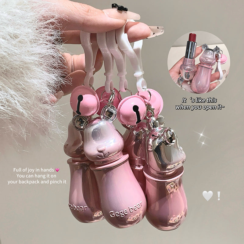 Pink bottle-shaped keychain with a flamingo charm held by a hand against a neutral background.