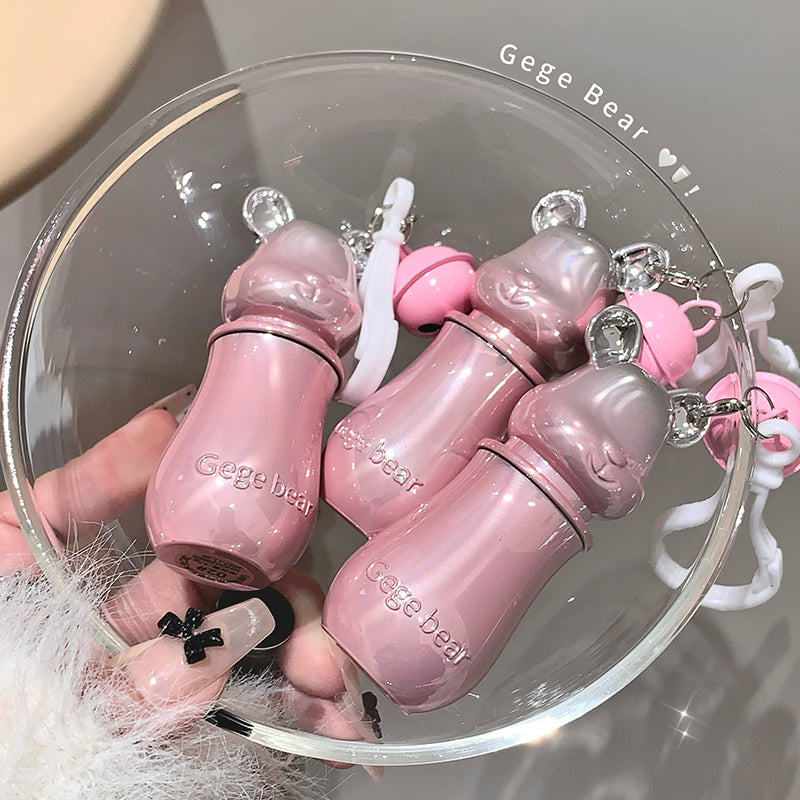 Pink baby bottle-shaped keychains with 'Gege Bear' branding on a clear glass dish.
