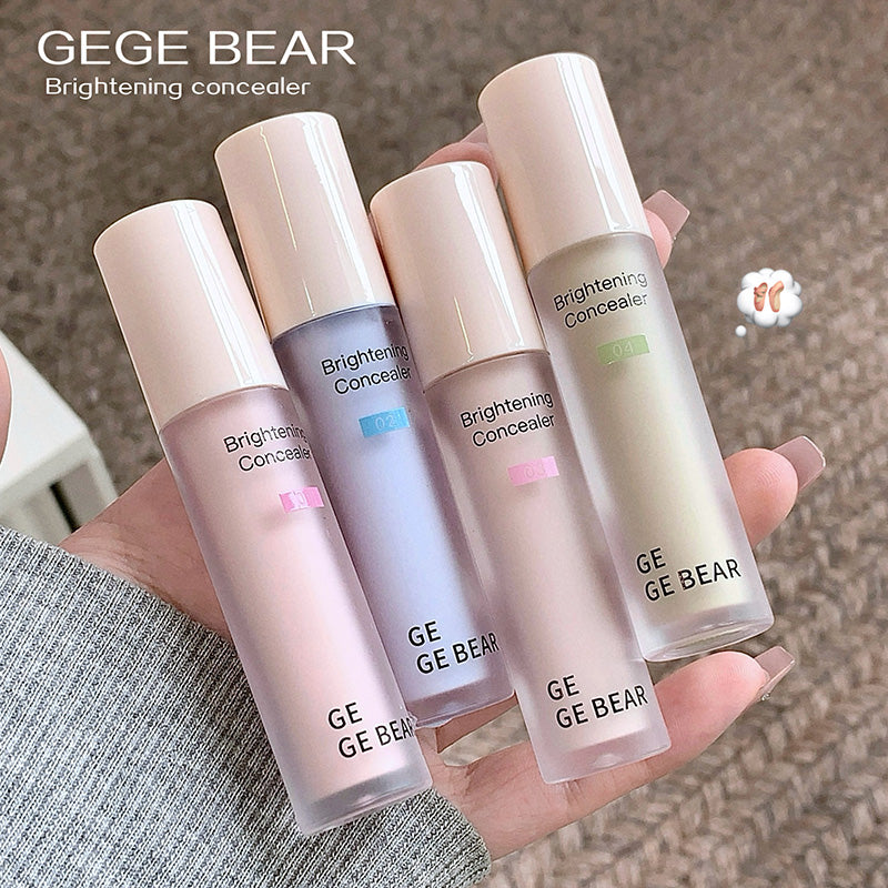 Five GE GE BEAR brightening concealers held in a hand against a neutral background.