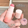Pink makeup stick with 'Gege Bear' branding held by a hand, with text and a small inset of a person's face.