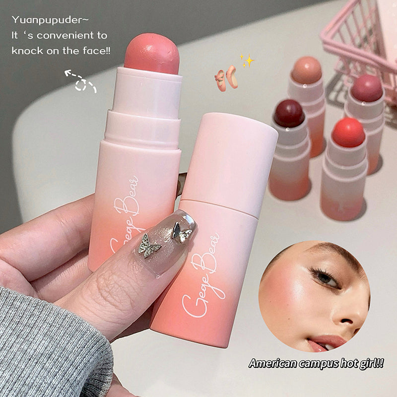 Two pink lip balms with visible brand name, hand holding one, and additional lip balms in the background.