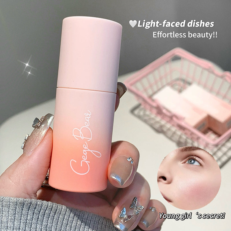 Hand holding a gradient pink bottle with 'George Bear' branding, surrounded by a blurred background.