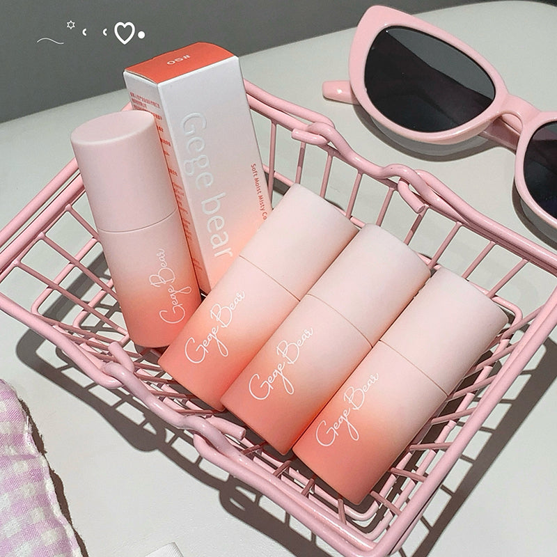 Set of pink and orange gradient bottles with a box labeled 'Geege Beauty' in a pink basket.