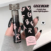 GEGE BEAR lip gloss bottle and packaging held by a hand on a light background