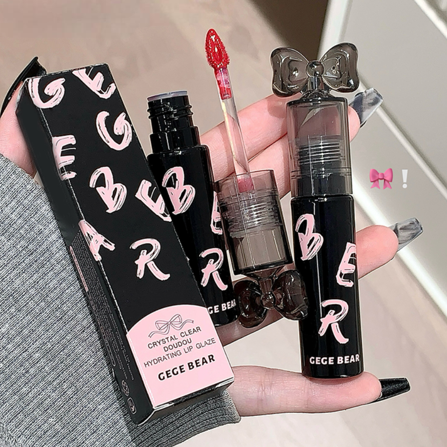Hand holding GECE BEAR lip products including a box, lip gloss, and other items.