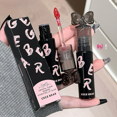 Hand holding GECE BEAR lip products including a box, lip gloss, and other items.