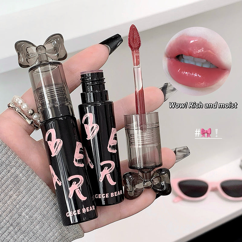 Black lip gloss with 'CESE BEAR' branding held by a hand, with a close-up of lips wearing the product.