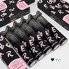 Black lip gloss tubes with pink text on a white surface