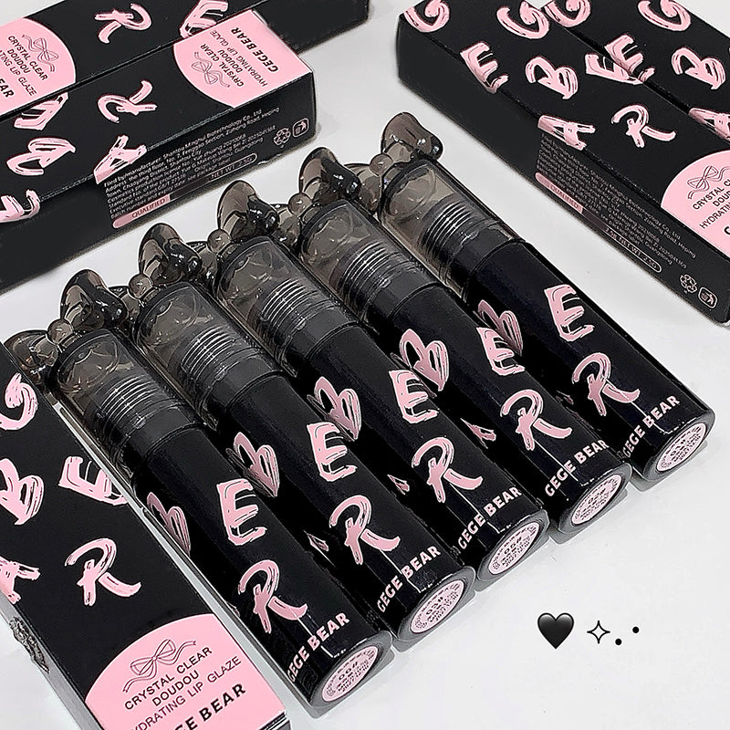 Black lip gloss tubes with pink text on a white surface