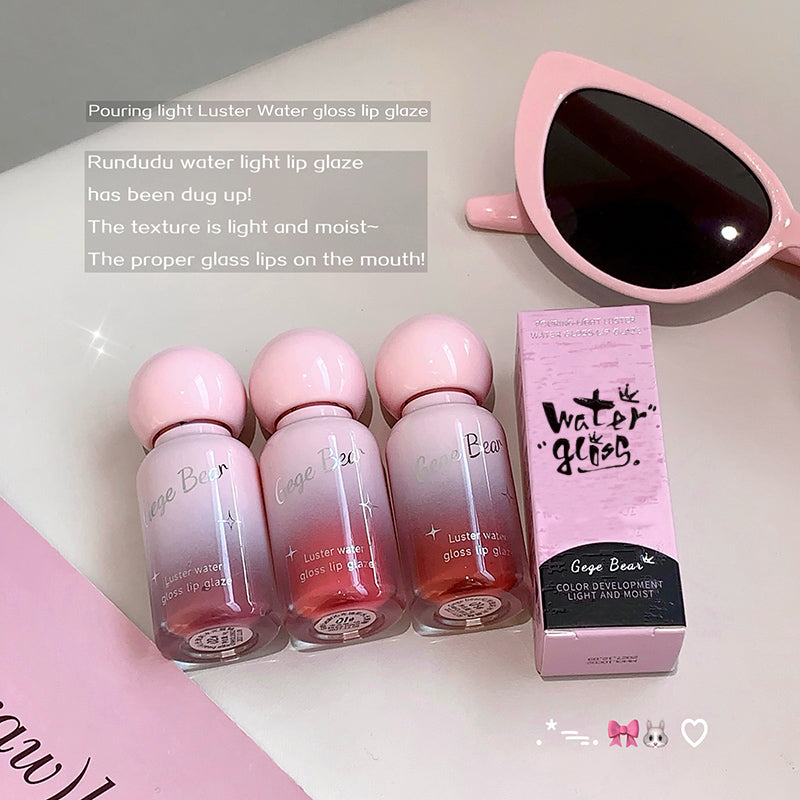 Set of Gaga Bear water gloss lip glazes with packaging and sunglasses on a light background