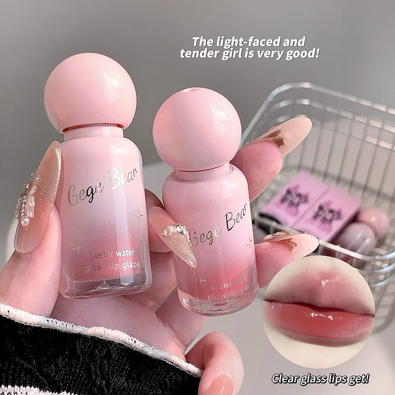 Two small pink bottles labeled 'Gege Bear' held by a hand with a blurred background.