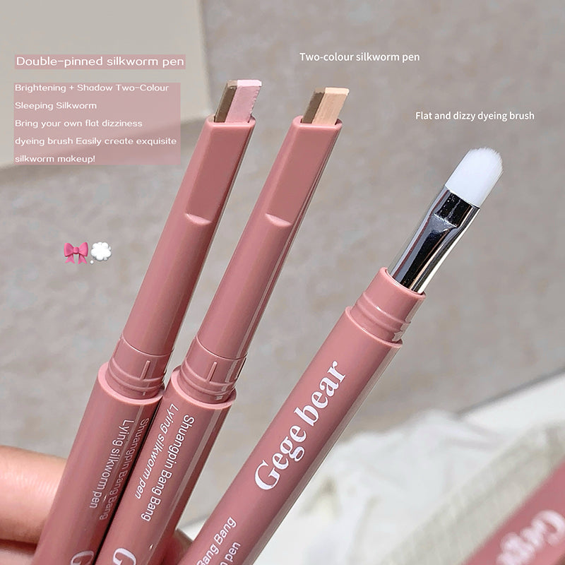 Three pink silkworm pens with brush attachments on a light background