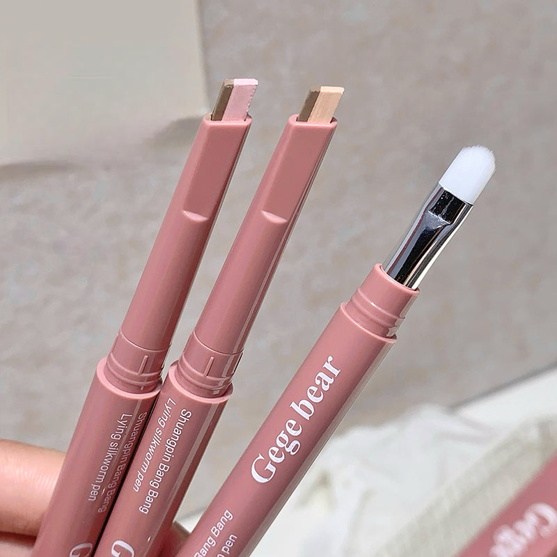 Three pink silkworm pens with brush attachments on a light background