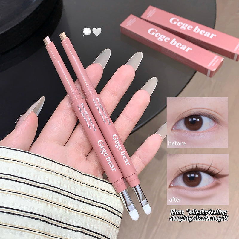 Three pink makeup brushes with silver tips held by a hand, next to 'Gege bear' packaging on a dark surface.