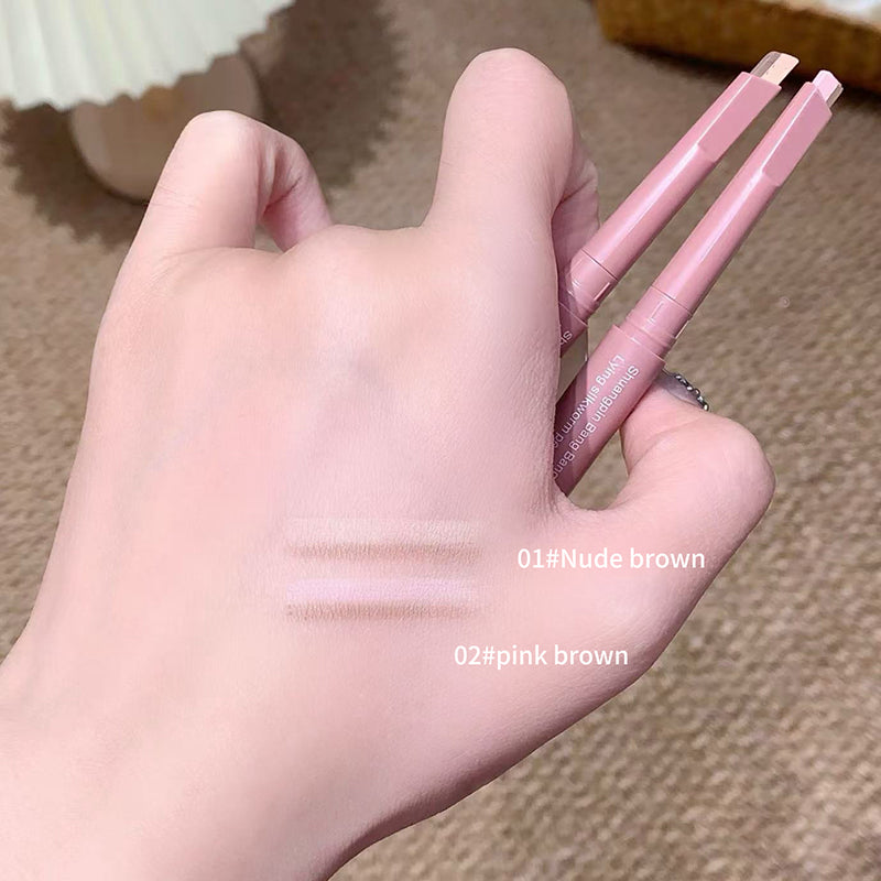 Hand holding two makeup pencils with color swatches on a textured surface