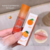 Lip oil with packaging held by a hand, showing a close-up of glossy lips.