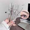 Hand holding multiple GEGER BEAR eyebrow pencils with a close-up of an eye wearing the product.
