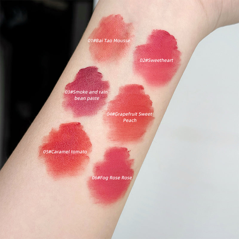 Lipstick swatches on a person's arm with color numbers