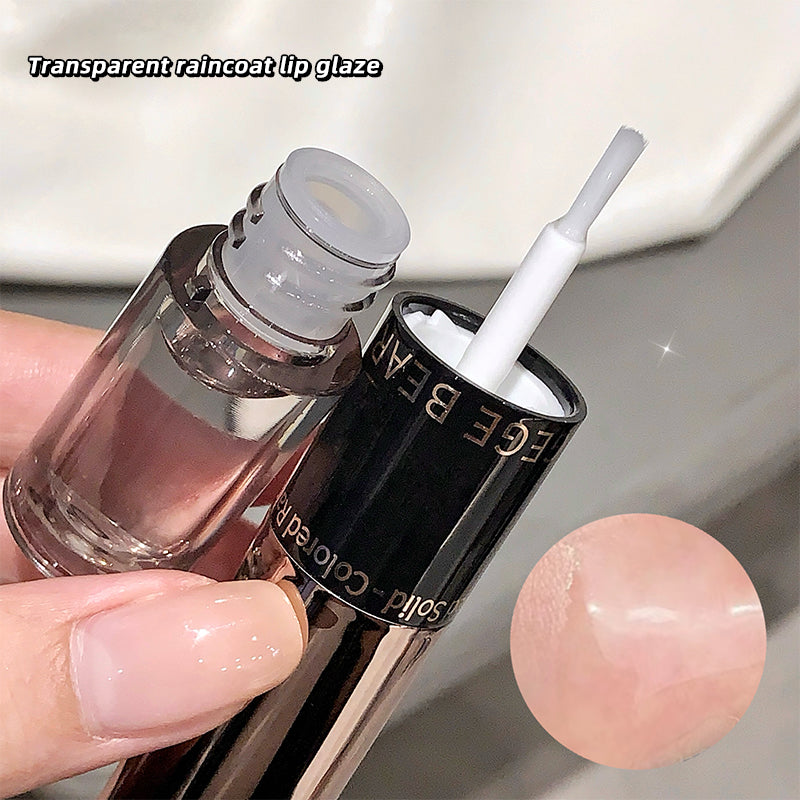 Transparent raincoat lip glaze with applicator held by a hand, showing a close-up of the product.