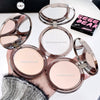 Compact powder cases with open lids showing different shades held by a hand.